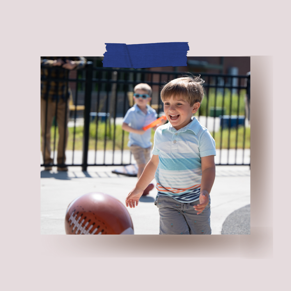 Little boy smiling and chasing a football on playground after worship service